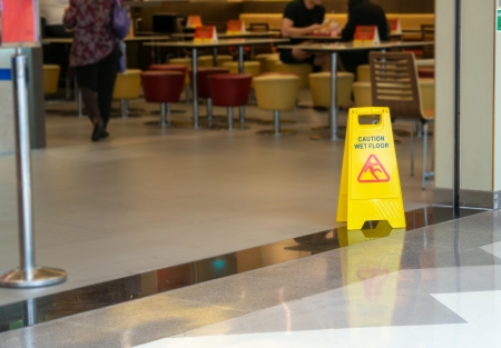 caution: wet floor sign at the entrance to a food court