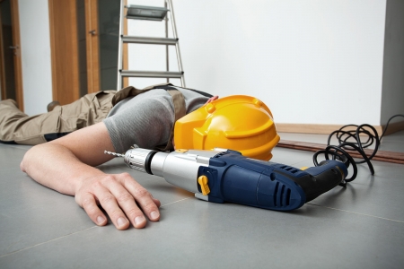 construction worker collapsed on floor next to power drill